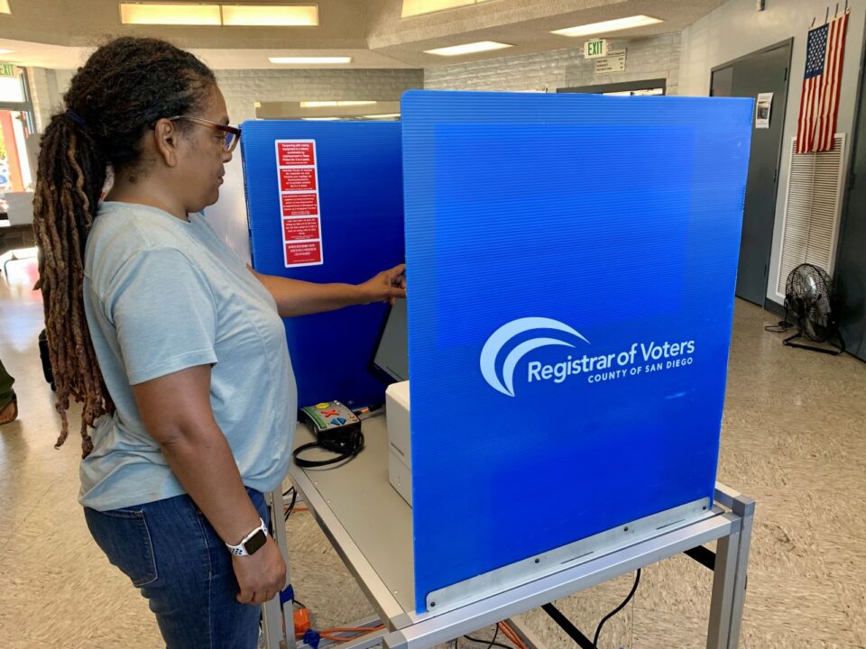 person stands at voting machine