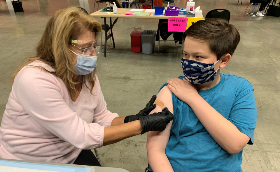 boy has band-aid placed on arm