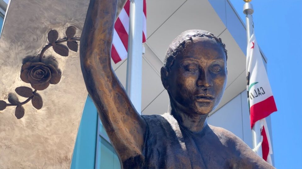 sculpture outside building with flags