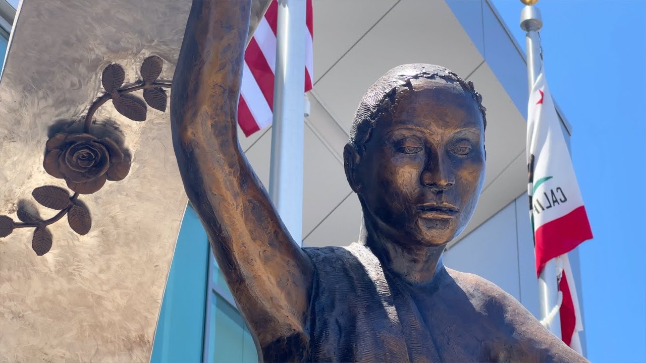 sculpture outside building with flags