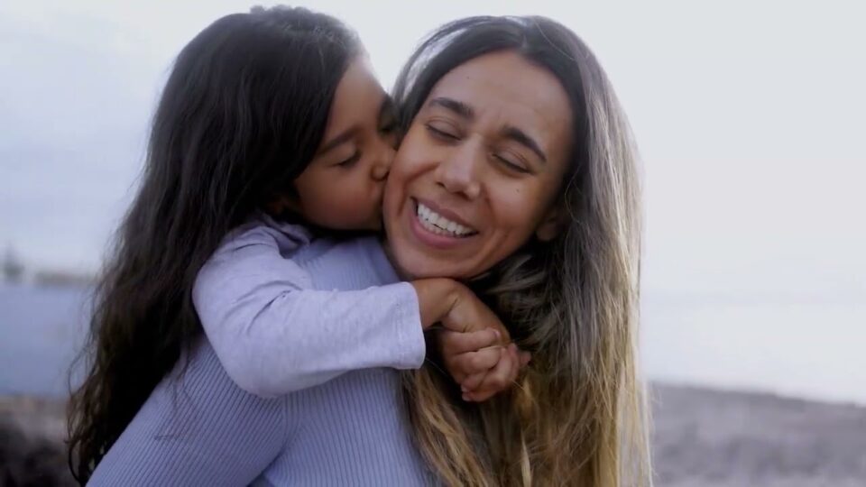 Child wraps arms around mom's neck