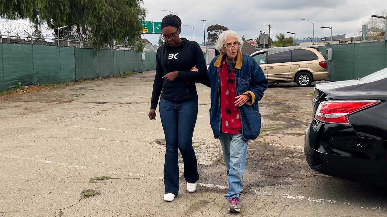 two people link arms in parking lot
