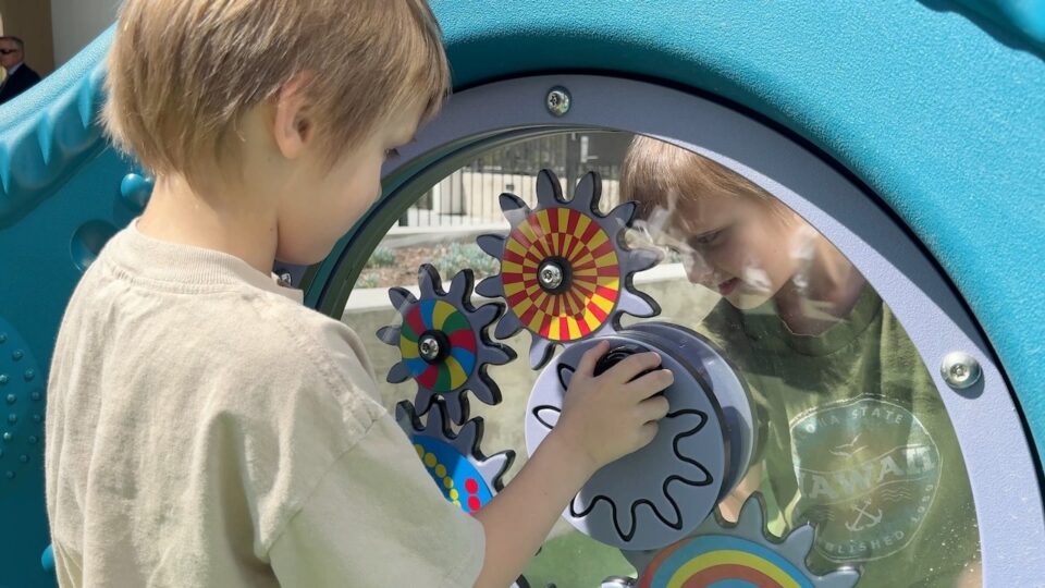 two children play on a playground outside a housing complex