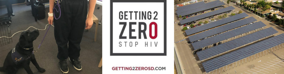 Training dog sitting at feet of a Probation youth, Getting 2 Zero logo and solar panels at a County facility.