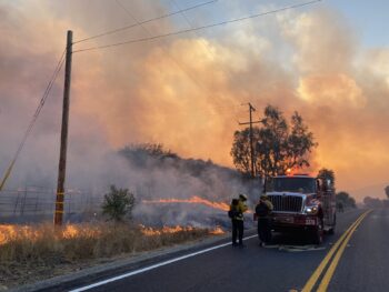 a fire crew in front of a giant blaze