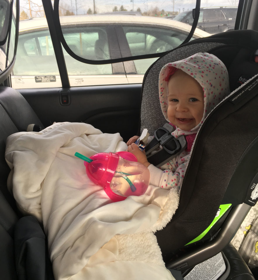 Infant sitting in a rear-facing car seat.