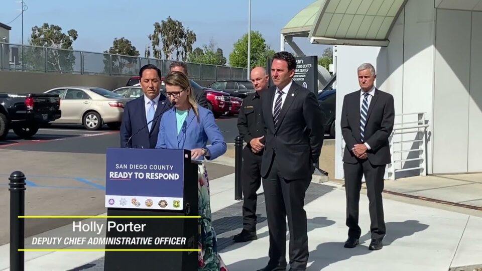 Holly Porter stands at podium in front of OES with other officials