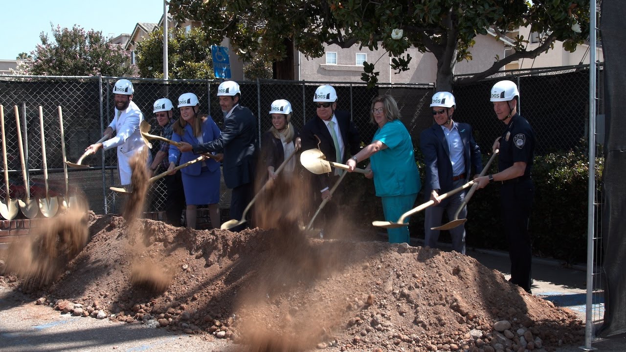 group of people with hard hats shovel dirt