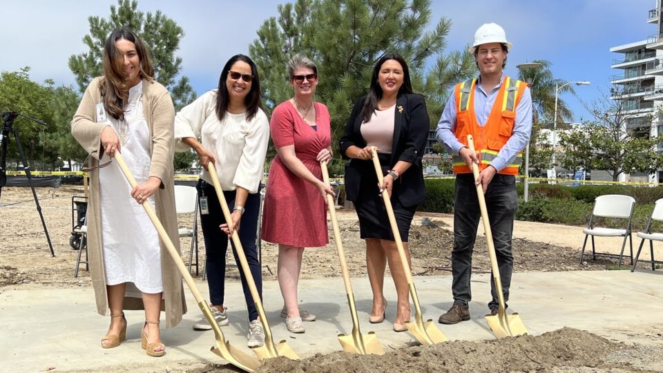 people stand outside for ceremonial groundbreaking
