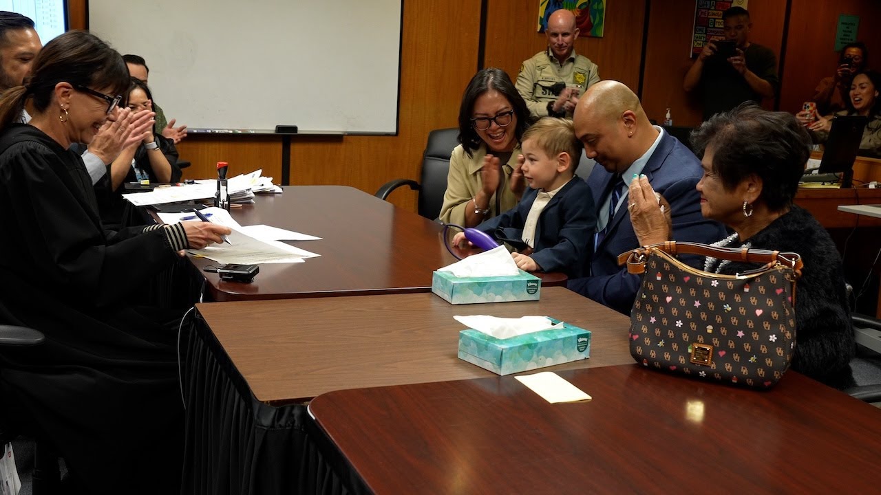 child sits between two adults at court hearing