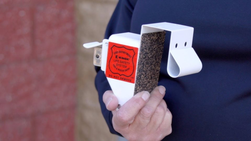 a man holds a knox box in his hand