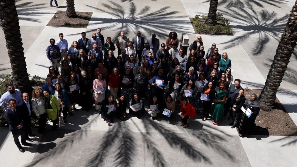 group of people stand outside an open plaza