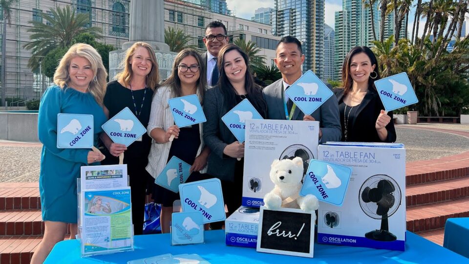Group stands at table with fans