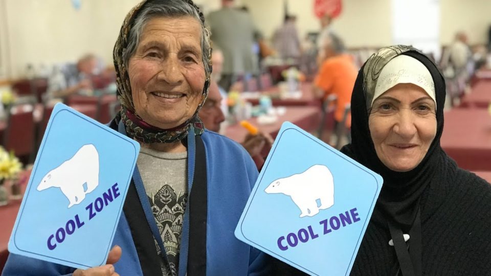 Two ladies hold Cool Zone signs