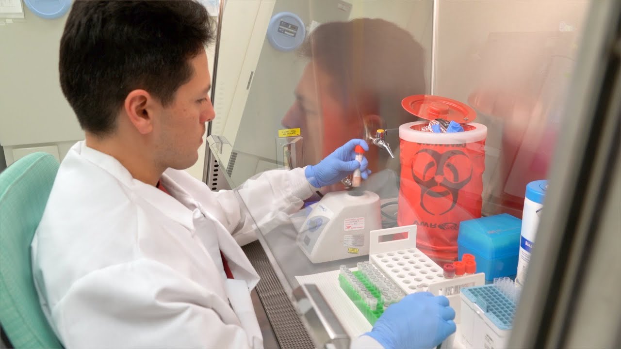 microbiologist prepares a specimen in a lab