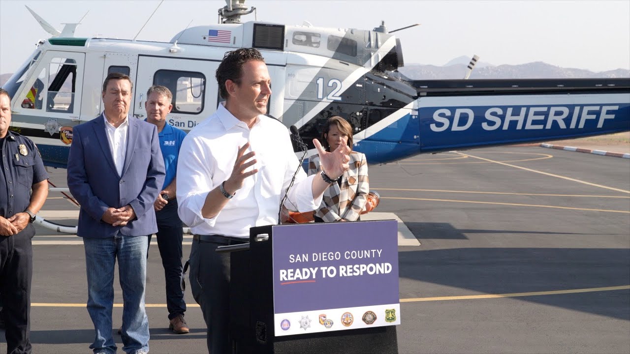 Chair Fletcher standing in front of a helicopter