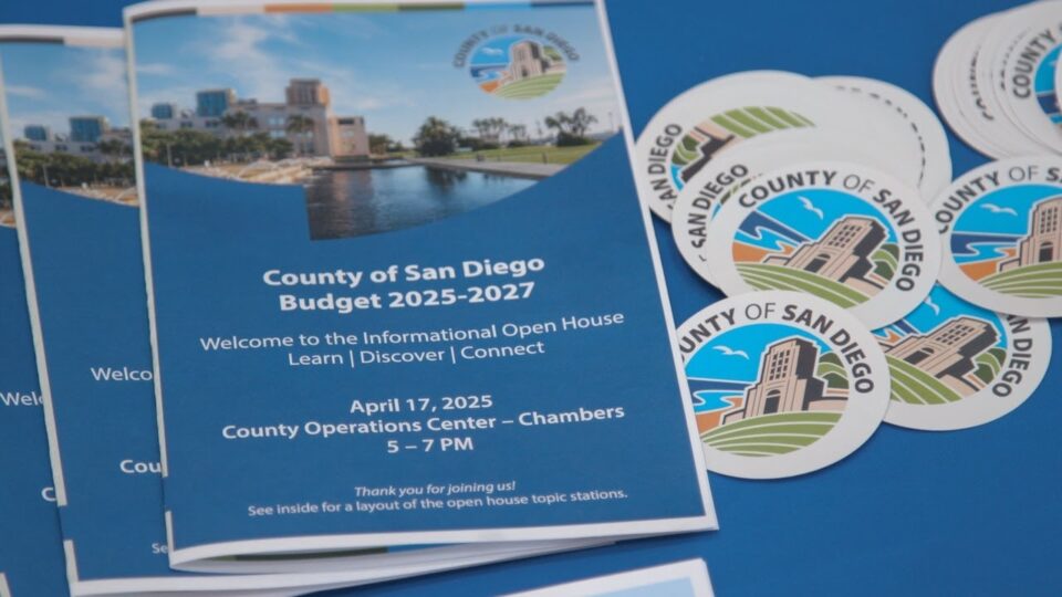 program and County logo stickers on a table