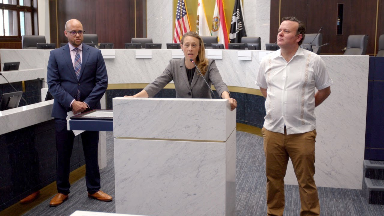 Terra Lawson-Remer stands besides two others at a podium