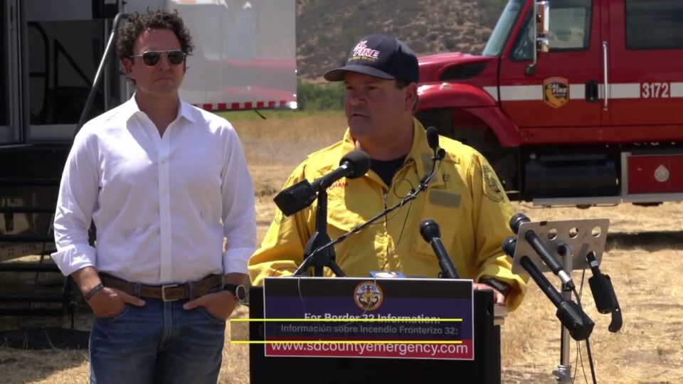 Chief Mecham at podium with engine behind him