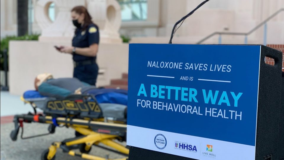 woman stands over mannequin on a stretcher