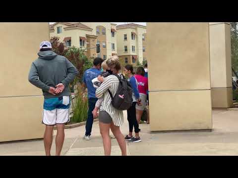people stand in line outside a COVID-19 testing site