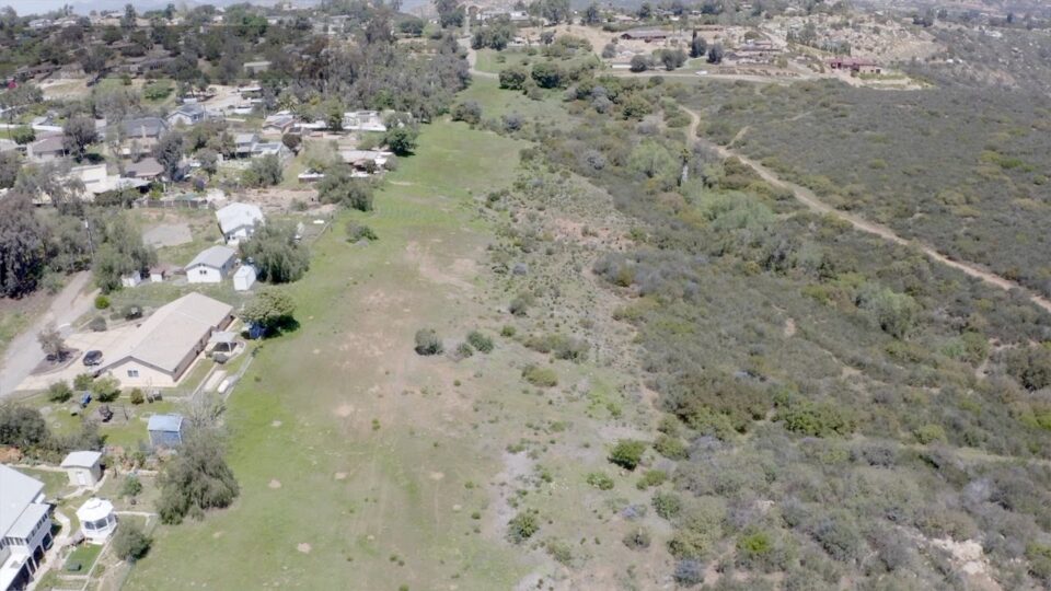 Aerial view of open area next to houses