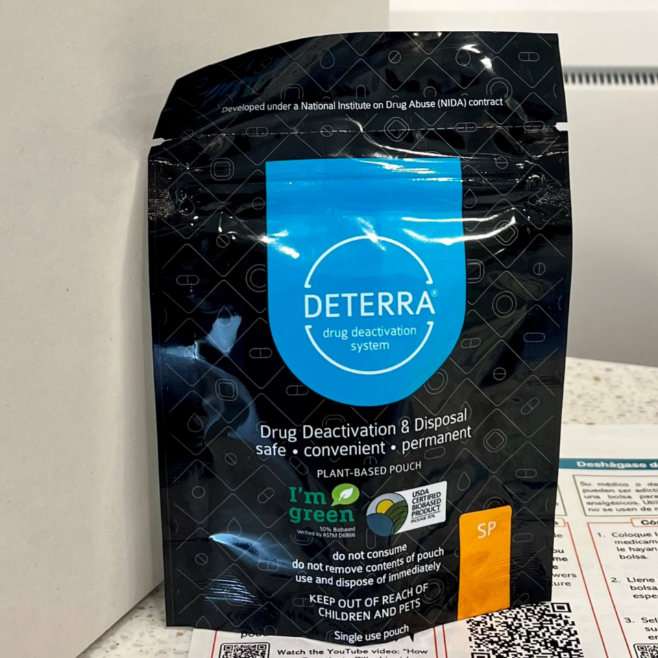 black bag with blue circle and little pill symbols