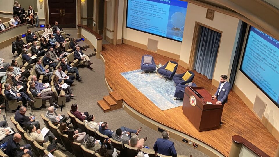 a look down into a full auditorium with a speaker on stage