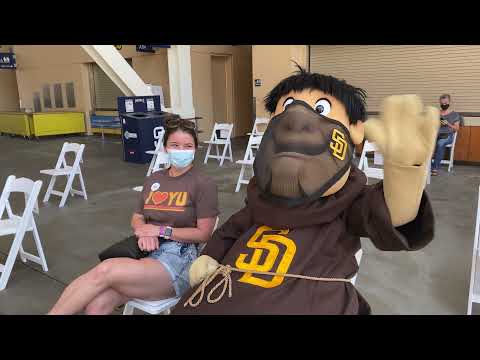 Padres Friar and a young female wear masks outside Petco Park