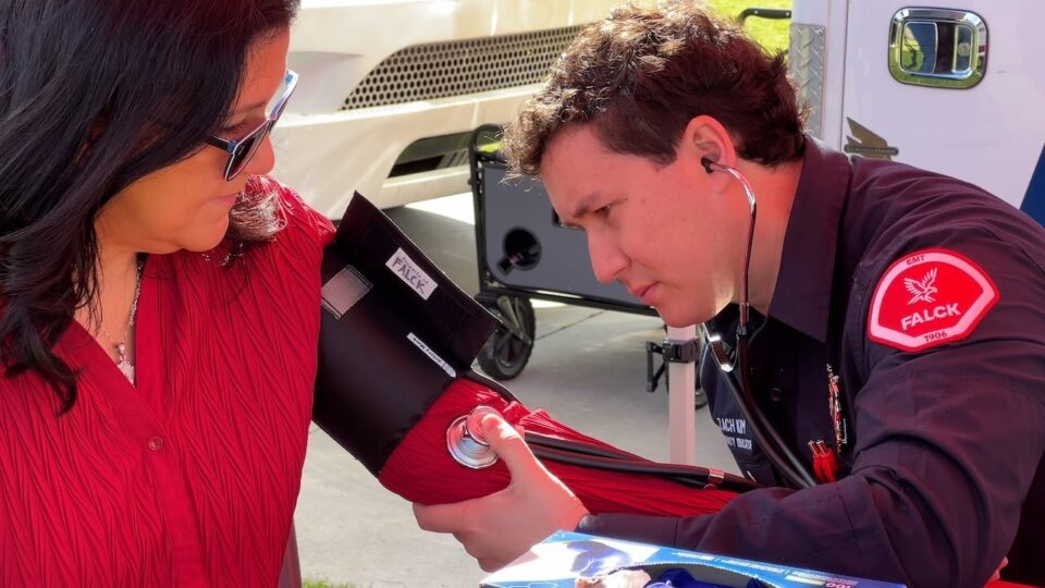 paramedic places blood pressure cuff over arm of patient