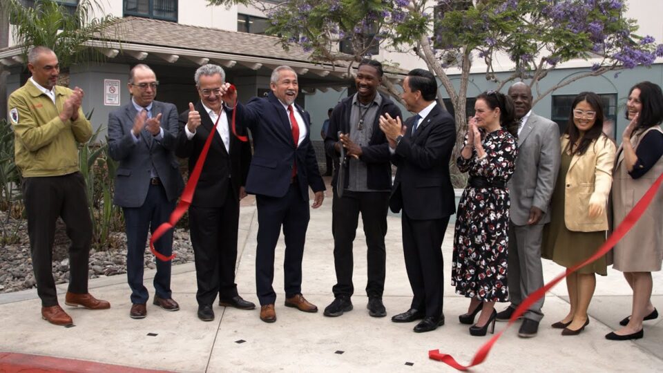 group does ribbon cutting outside affordable homes