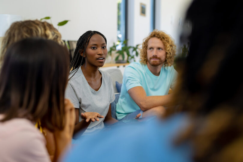 stock image showing people sitting in a circle and speaking