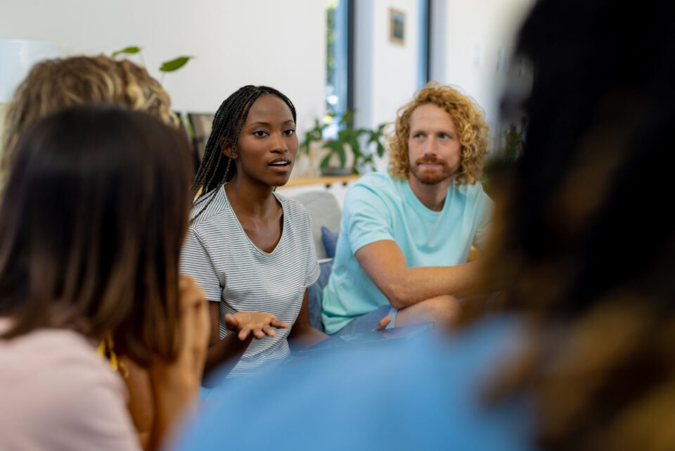 stock image showing people sitting in a circle and speaking
