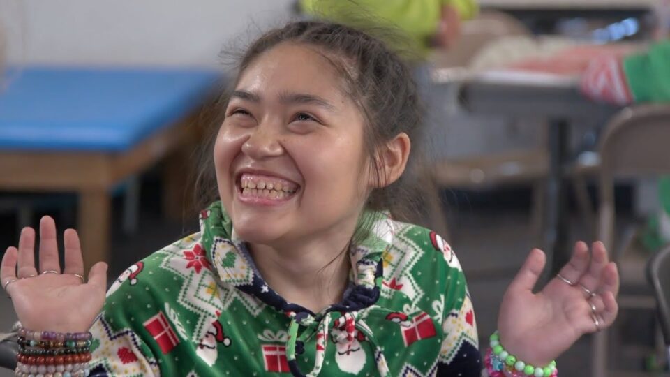 child smiles wearing holiday pajamas