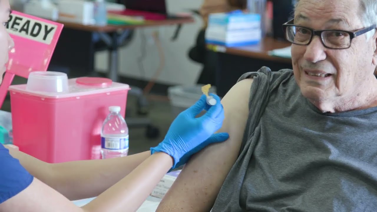 person wearing glasses gets vaccine