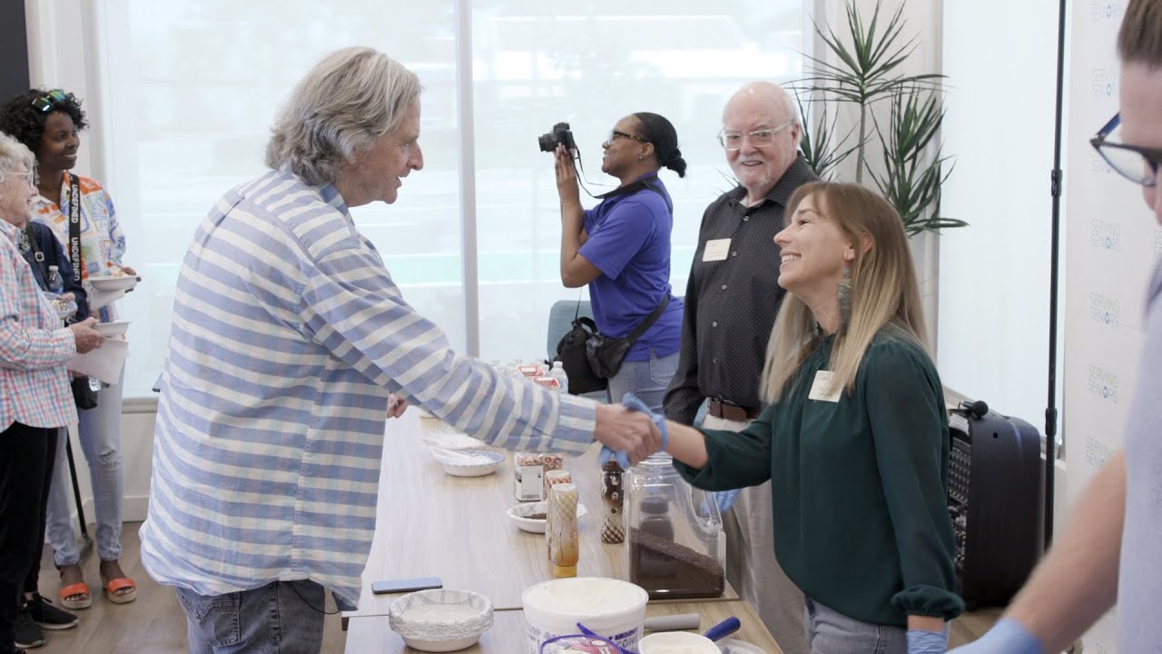 two people shake hands across table