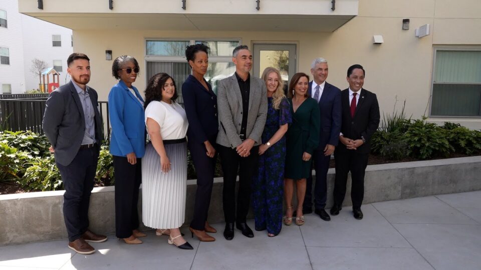 group of people stand in front of apartment