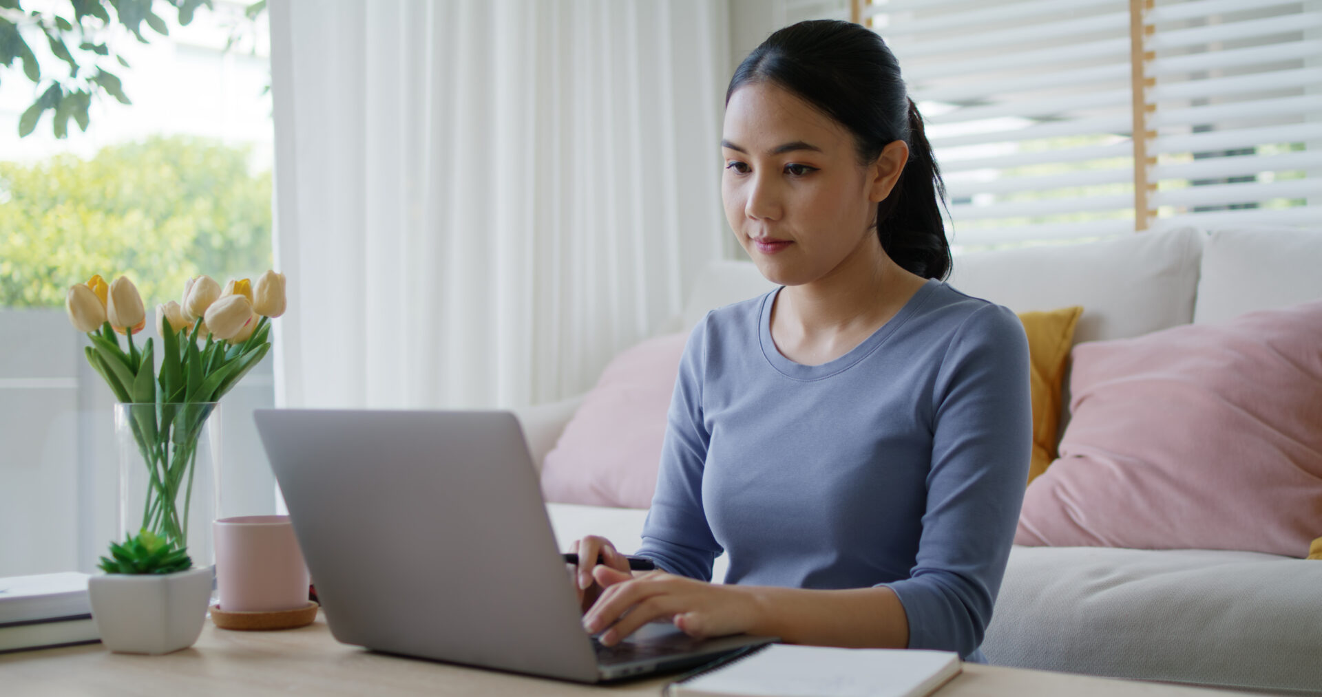 Woman sits and works on laptop