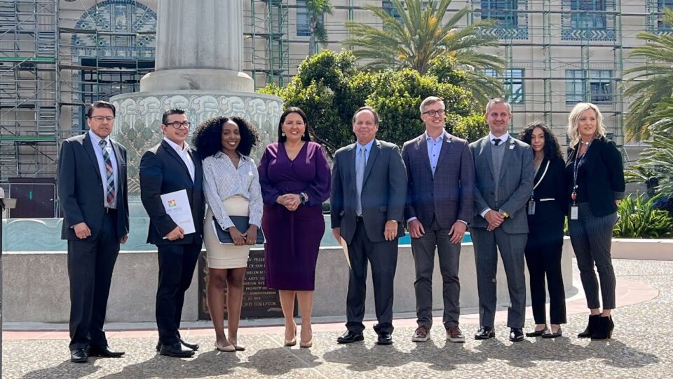 group stands in front of fountain outside the County Administration Center