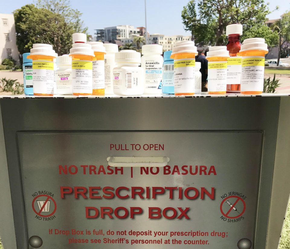 Picture of a Sheriff's Prescription Drug Drop Box with medication bottles on top.