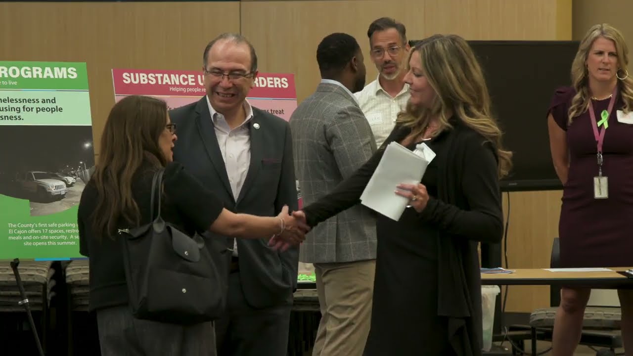 people talk amongst themselves in a meeting room