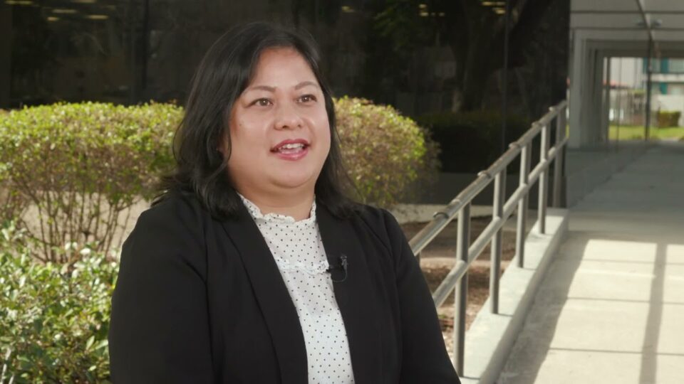 woman stands in front of building