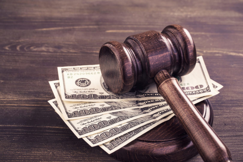 gavel and cash representing criminal fees.