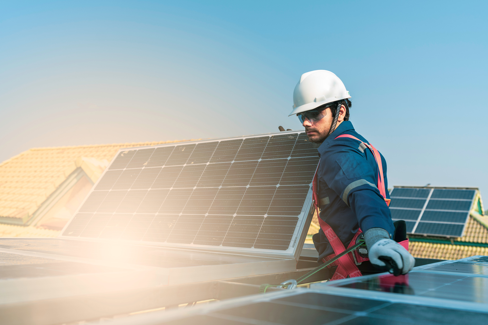man works on a roof with a solar panel
