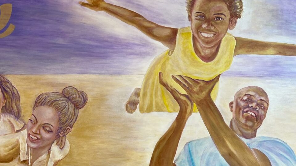 drawing of a man holding up a young girl in a yellow dress with a woman to his right