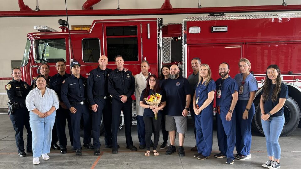 group of firefighters and medical team stand in front of fire engine