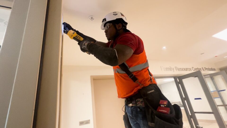 person works on installing a light into the wall
