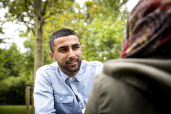 View over shoulder on man looking at friend