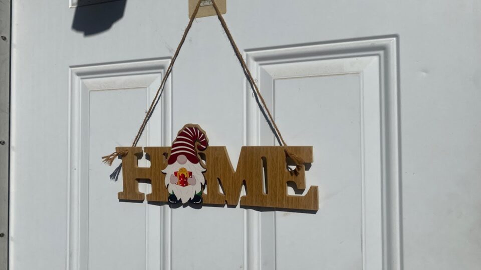 front door with "home" sign hanging